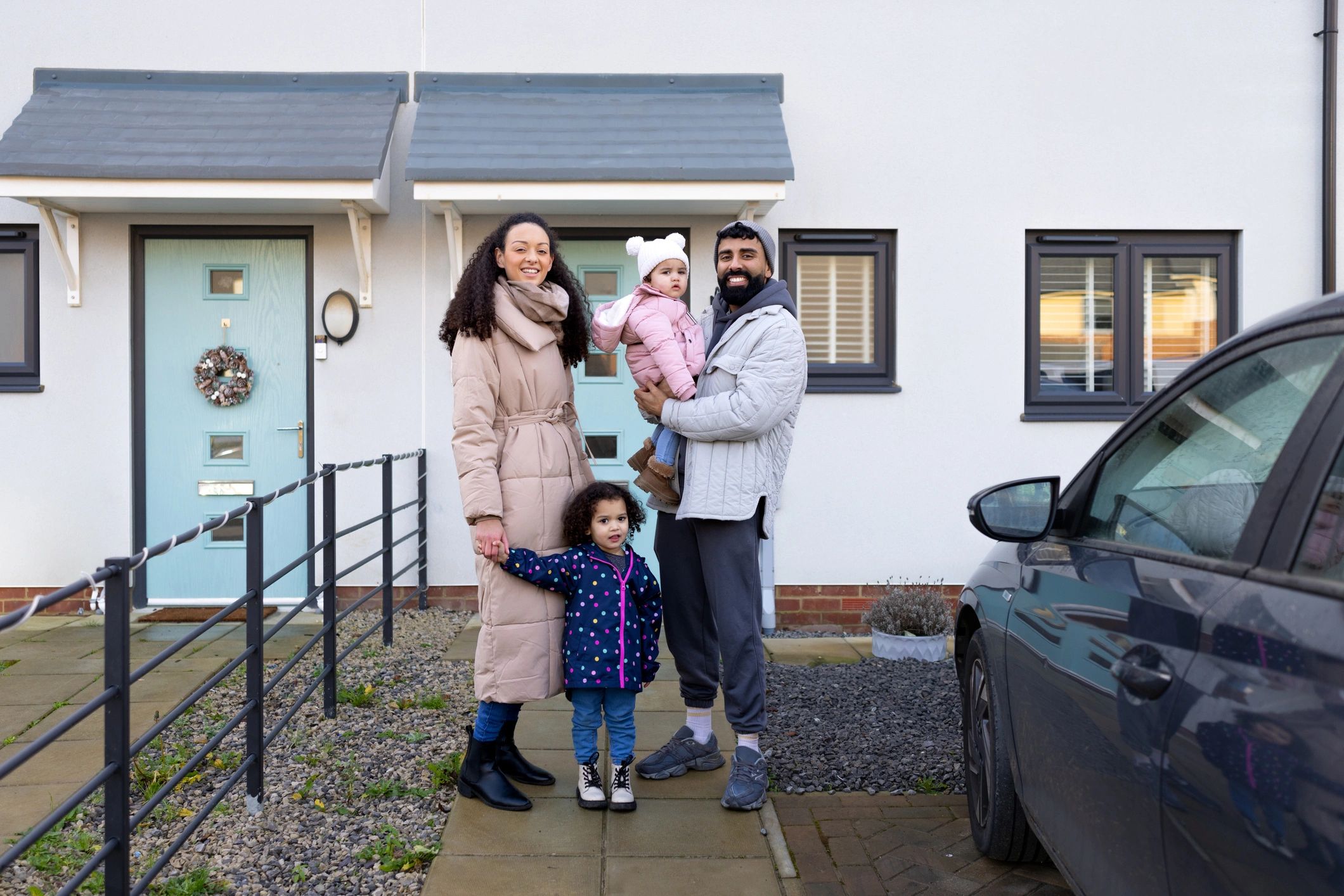Happy family outside their home